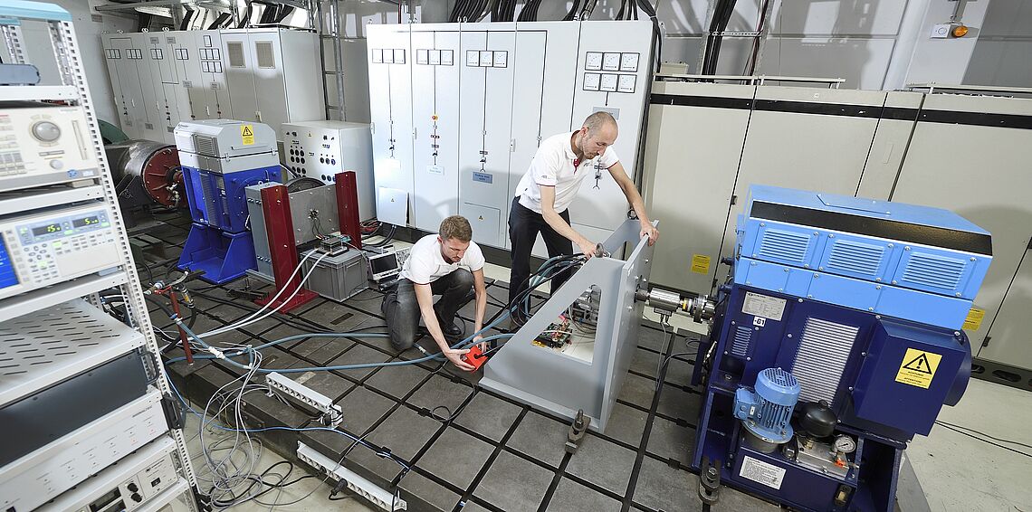 Zwei Männer im Antriebslabor führen einen HIL-Hardware in the Loop-Test