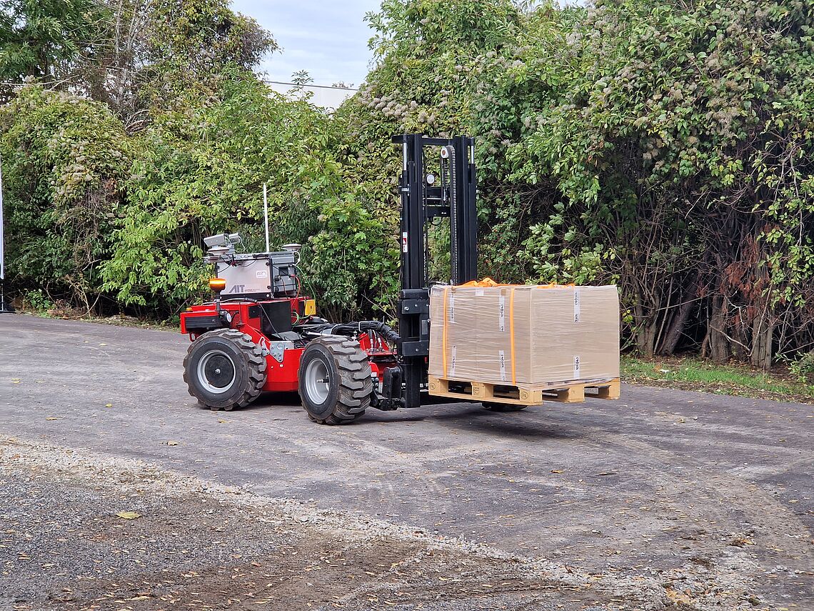 Autonomous forklift truck with transported goods on a pallet on the AIT outdoor test site, the Large-Scale Robotics Lab