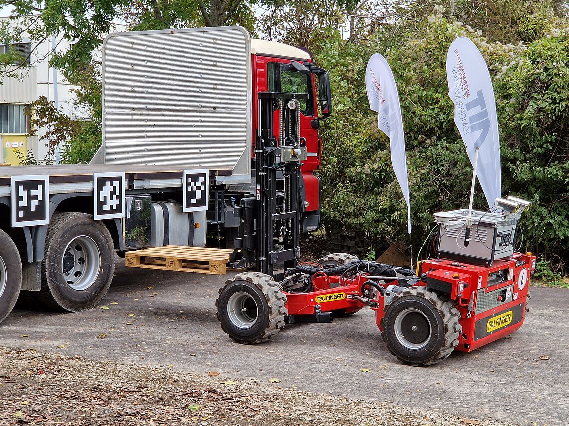 Autonomous forklift truck loading a pallet on a truck on the AIT outdoor test site, the Large-Scale Robotics Lab