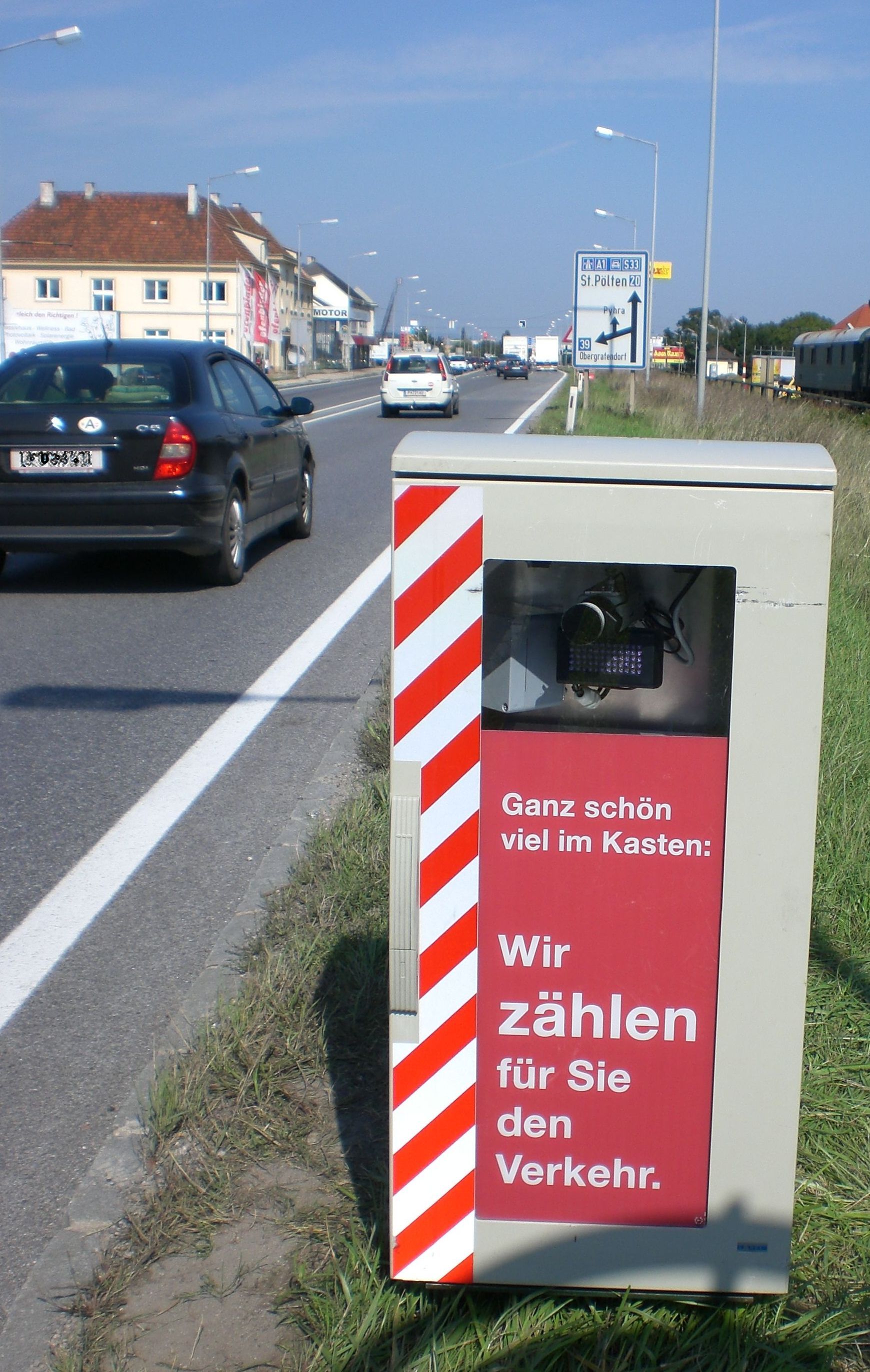 radar unit with the inscription "quite a lot in the box. We count traffic for you"; In the background is a busy street