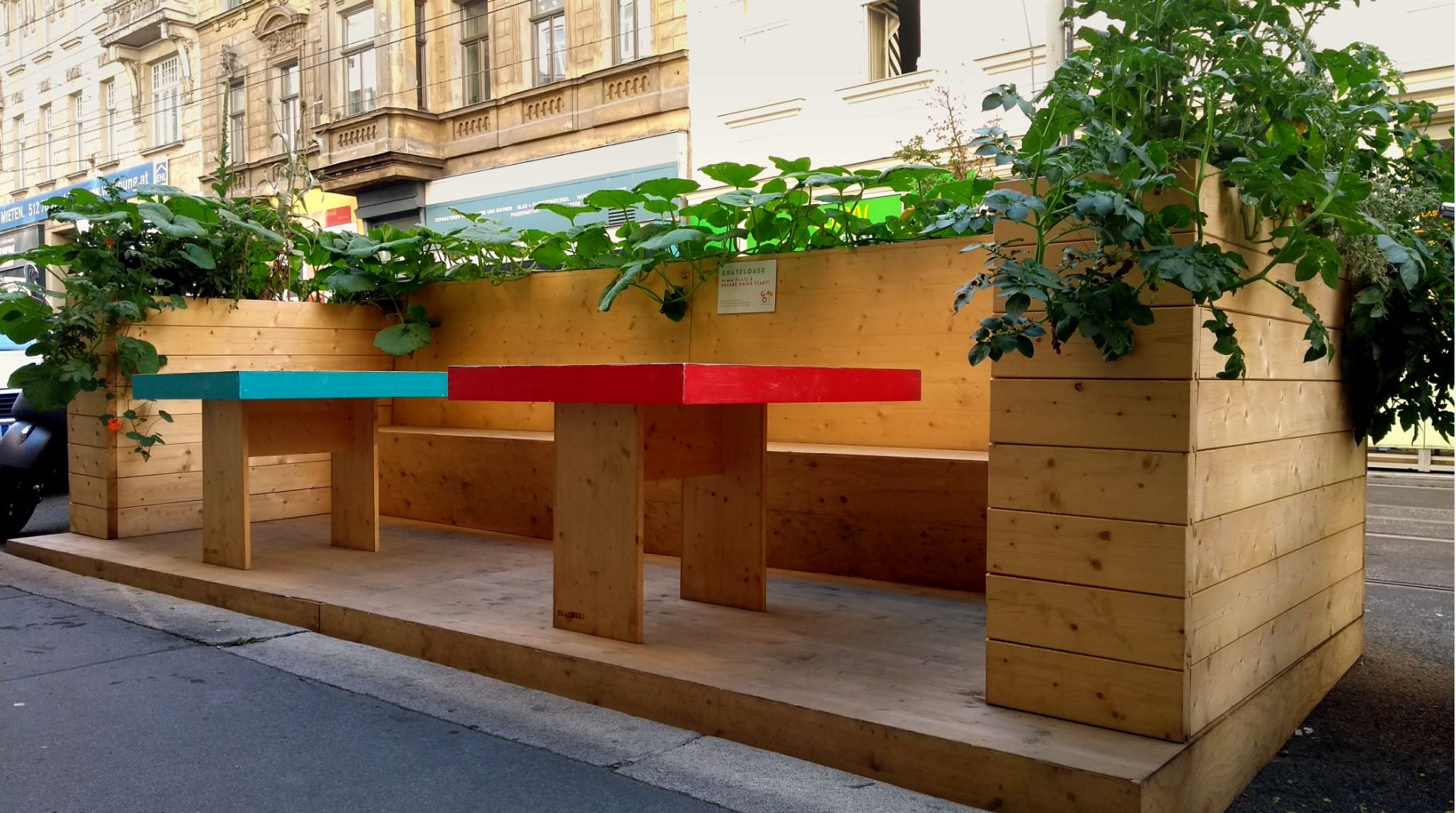 small sitting space made out of wood by a street