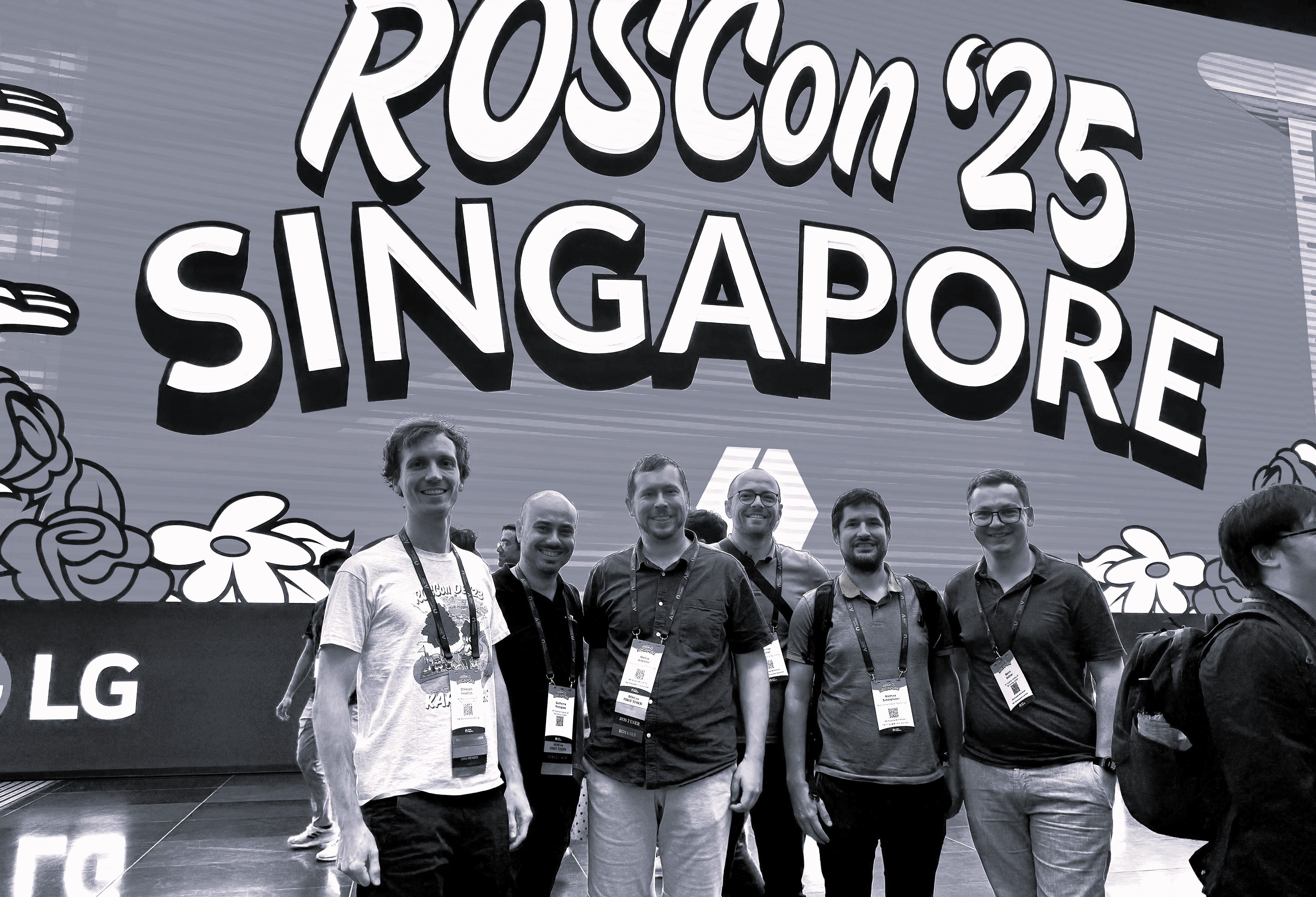 AIT employees at RosCon – in front of the logo