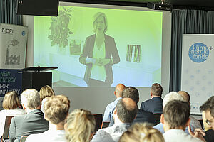 Foto: Leonore Gewessler (BMK) spricht per Videobotschaft zum Publikum