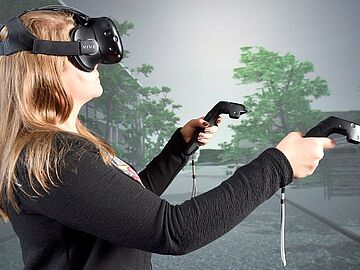 Woman with VR-glasses and controllers in her hand