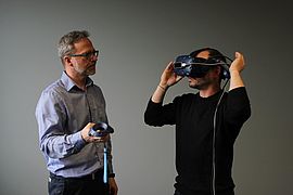 Das Bild zeigt Helmut Schrom-Feiertag und einen Teilnehmer der die VR-Brille trägt.