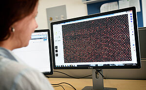 Wissenschaftlerin schaut auf den Bildschirm mit Bioinformatik-Daten