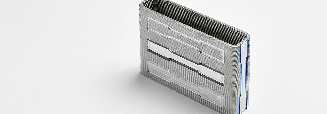 WAAM-Bauteil Metallblock mit Zugproben auf weißem Hintergrund