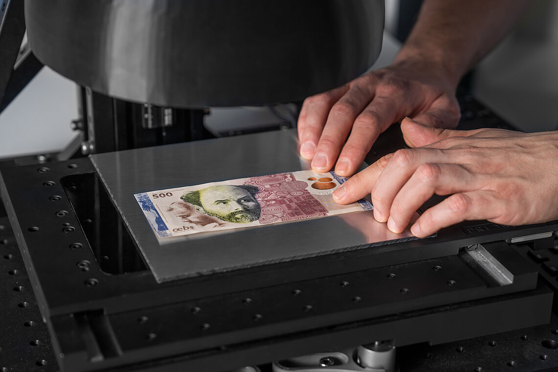 Hände tasten feinste 3D Details einer Klimt Testbanknote (von der OeBS zur Verfügung gestellt), Testbanknote liegt unter dem 3D Mikroskop ici:microscopy