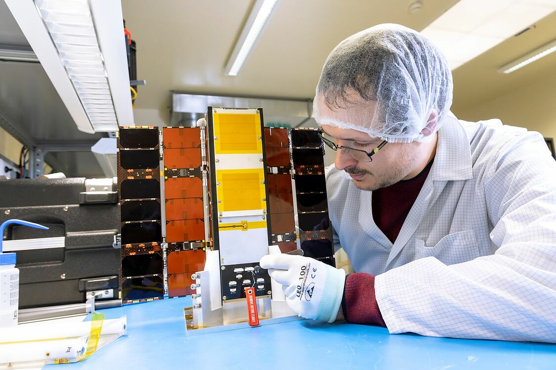 A scientist works on the satellite