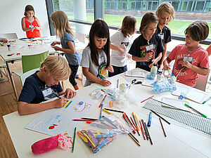 Kinder malen an einem Tisch