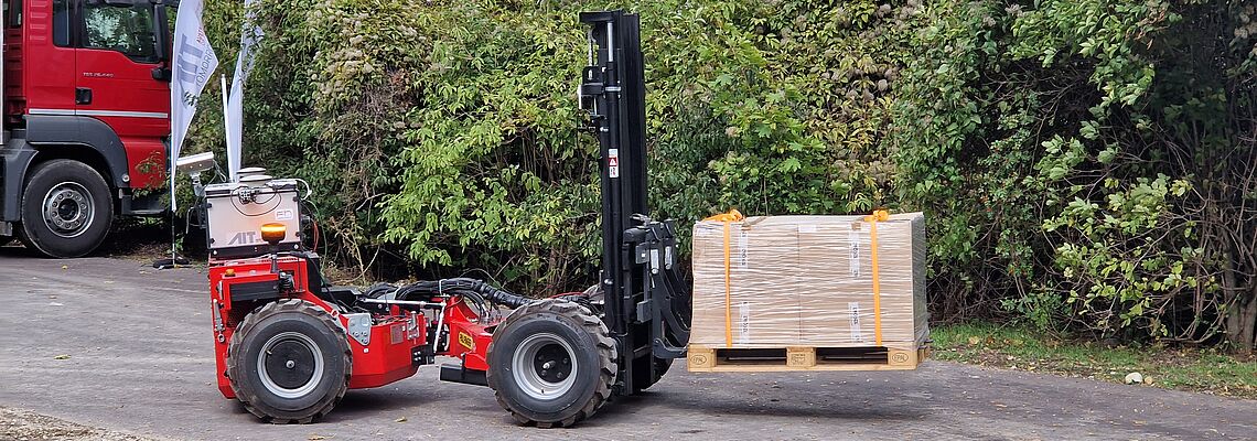 Automated forklift truck, here a Crayler, moves to the truck with goods on a pallet.