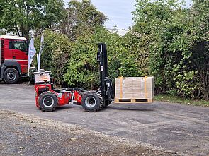 Automated forklift truck, here a Crayler, moves to the truck with goods on a pallet.