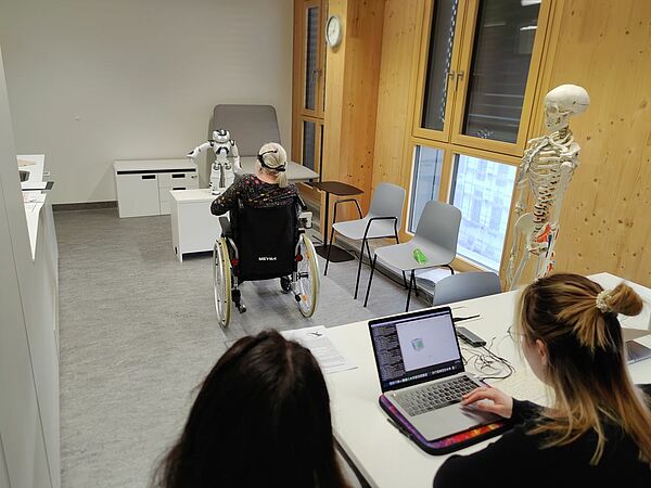 Studien-Setting: Weibliche Patientin im Rollstuhl beim Roboter-Training