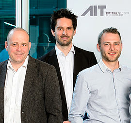 Siegfried Wassertheurer, Christopher Mayer und Stefan Hagmair stehen gemeinsam vor einem AIT Roll-up