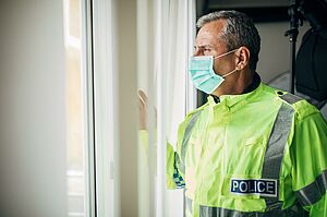 men in a police security jacket and a mask on his face