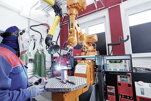 [Translate to English:] Arbeiten an einer Maschine im Additive Manufacturing Laboratory