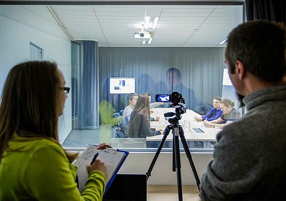 Two people observe focus group