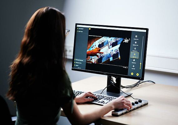 Woman sitting in front of PC with OptiVID surface.