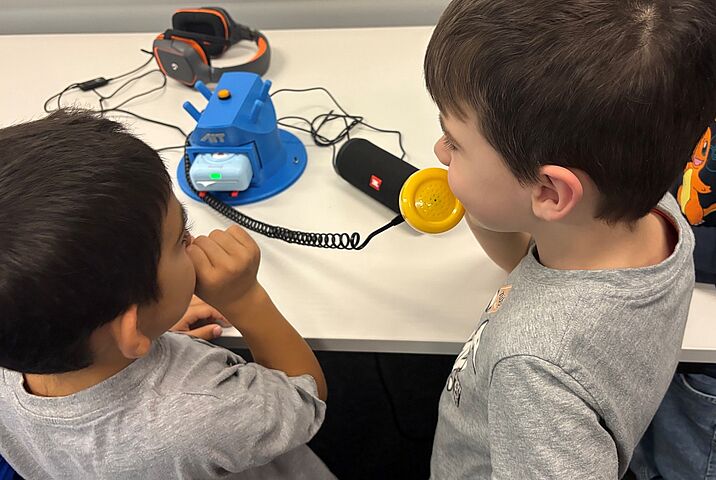 Zwei Kindergartenkinder mit dem WISPER Telefon