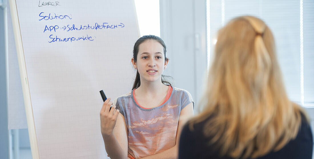 [Translate to English:] zwei junge Frauen vor einem Flip Chart