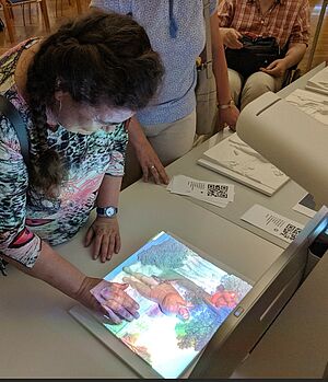 old woman with tactile multimedia guide