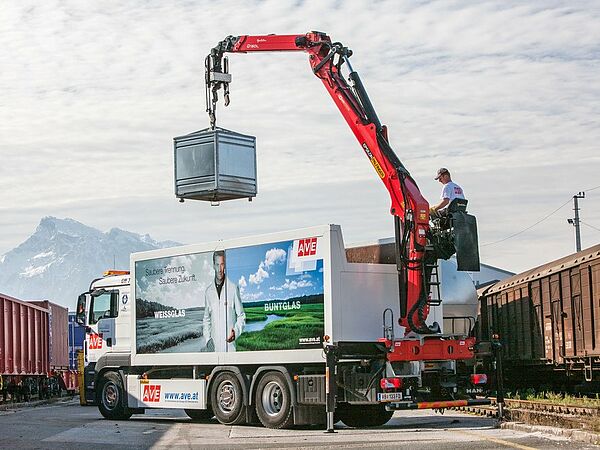 Glass container - recycling with a mobile crane ,Person steers the crane. ©Palfinge