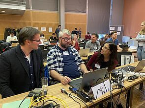 TeilnehmerInnen der Konferenz beim sog. Plugfest beim Testen der Kompatibilität von Computern und Cameras