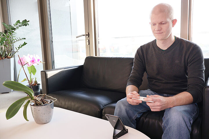 Mann mit SmartPWA Gerät schaut auf Smartphone Display