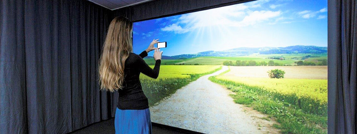 [Translate to English:]Woman standing in TX Lab looking at big screen