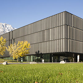 modern looking building on a field with mountains in the background
