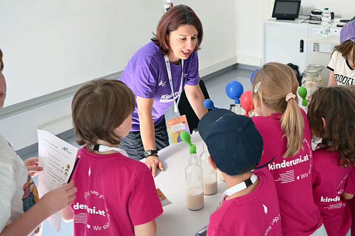 Forscherin macht wissenschaftliches Experiment mit Kindern