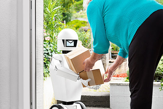 kleiner Roboter bringt ein Paket einer älteren Dame zur Tür