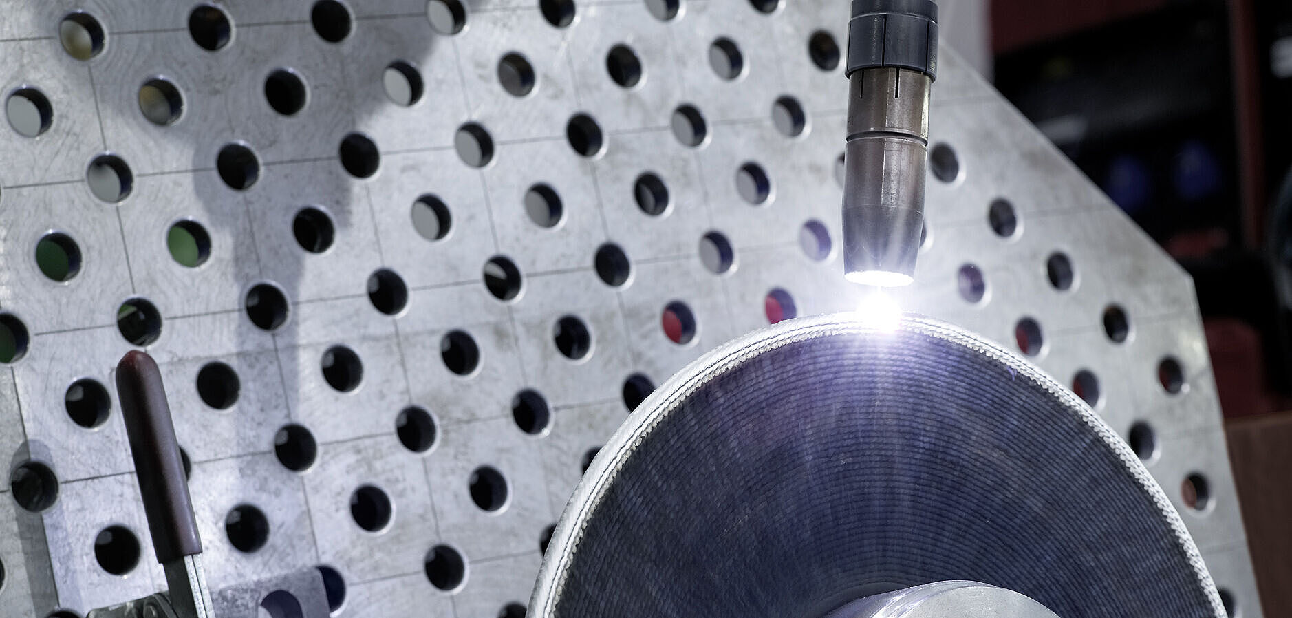 Nahaufnahme Schweißarm mit Lichtbogen und Bauteil