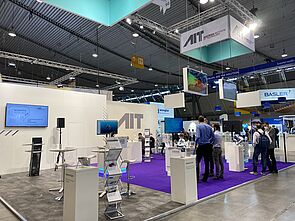 AIT booth, purple carpet, demonstrators, showcases