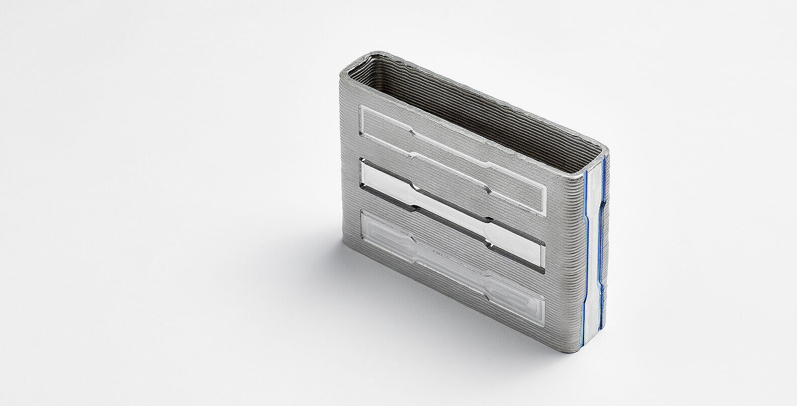 WAAM-Bauteil Metallblock mit Zugproben auf weißem Hintergrund