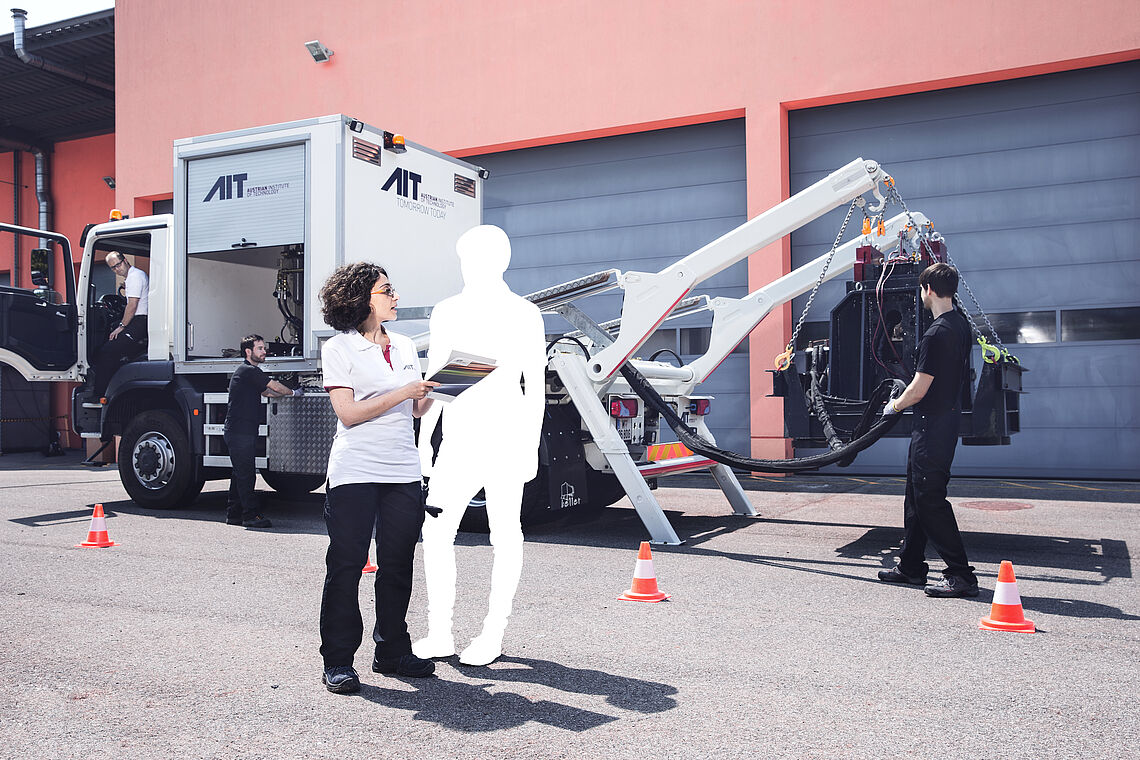 Frau und geweißte Person besprechen sich vor einer Maschine