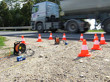 vibration measurement on the ground under a road where a truck drives over it 