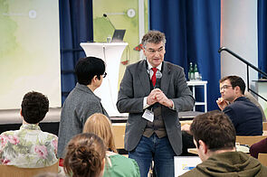 Sprecher steht im Publikum und antwortet auf Fragen