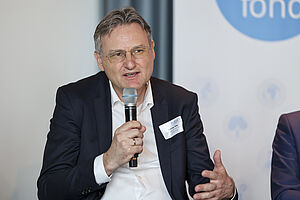Foto: Andreas Kugi (AIT) wie er mit einem Mikrofon in der Hand spricht
