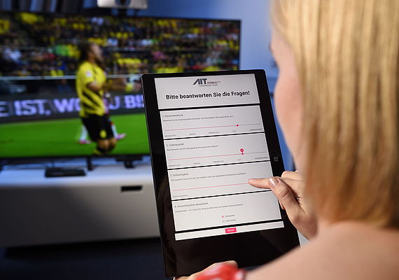 Woman watching a soccer game and filling out a questionnaire 