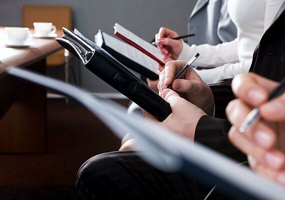 Usability Training: Close-up of clipboards held by people.