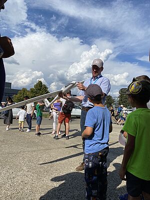 Christoph Sulzbachner vom AIT erklärt Kindern ein unbemanntes Flugzeug