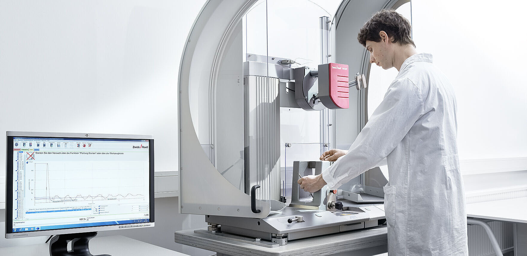 Wissenschaftler legt Probe in Pendelschlag-Anlage ein