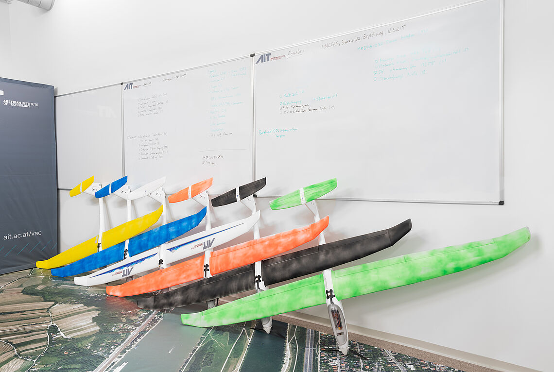 Model airplanes in different colors lined up on the wall in the AIT Aerial Systems Lab