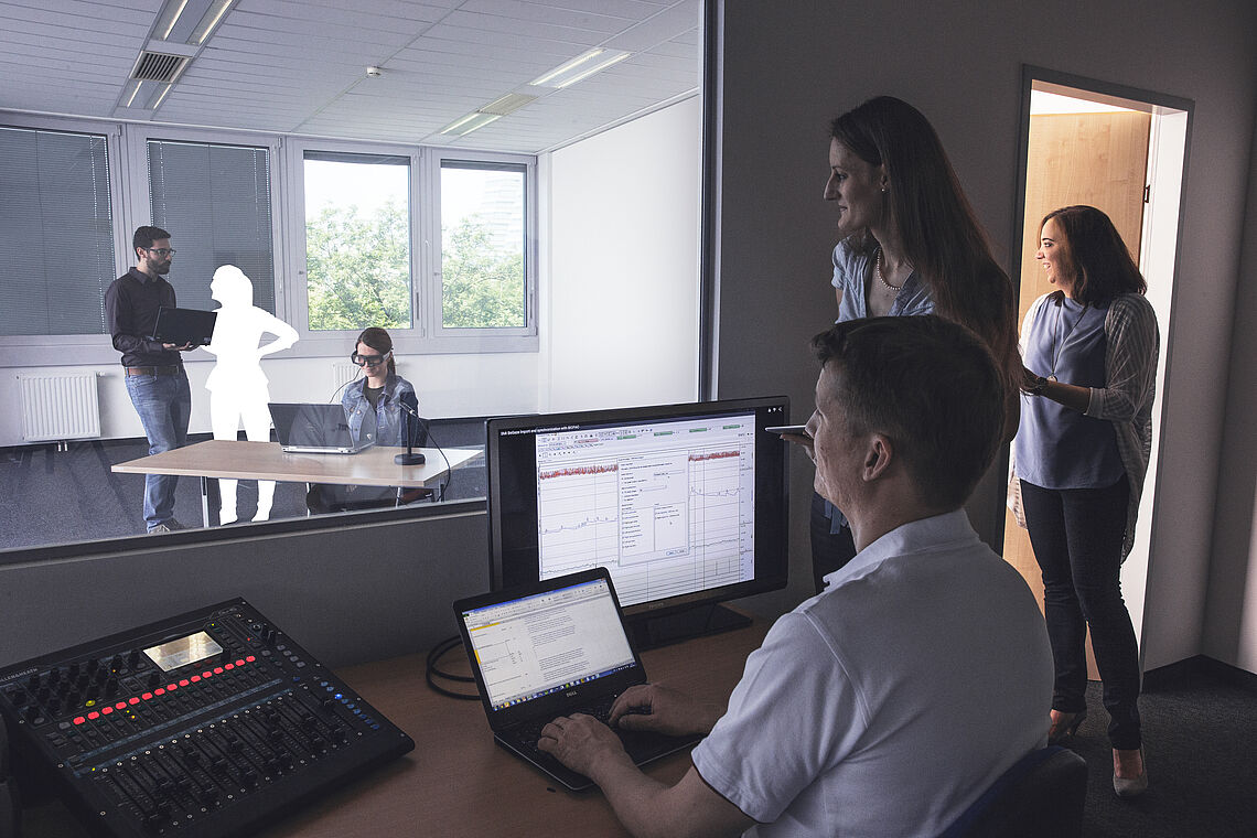 Personen beobachten Probanden durch Glasfront