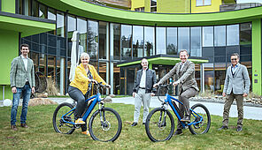 Group photo with the electric bikes in front of a hotel