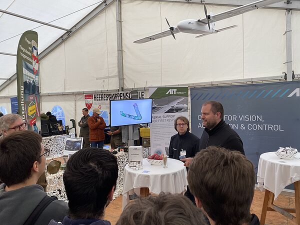 AIT scientist F. Bruckmüller talking to people at the AIT booth at Austrian National Day