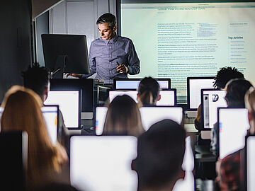 lecturer shows attendees something using the beamer