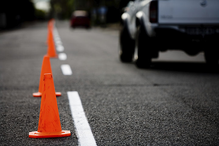 Traffic cone on a road with passing cars