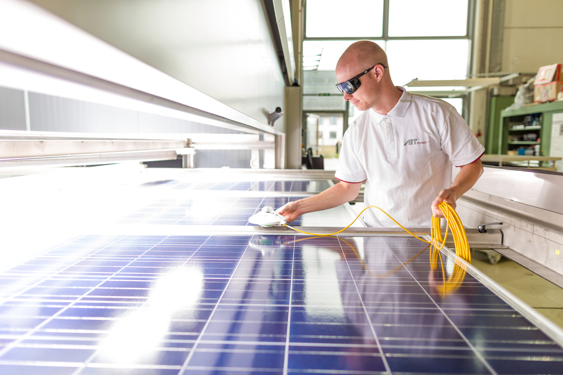 AIT Mitarbeiter arbeitet an einer Photovoltaikanlage